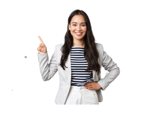A woman with long dark hair, wearing a light gray blazer and striped shirt, smiles and points upward with her right index finger. Her left hand rests on her hip. The background is plain white.